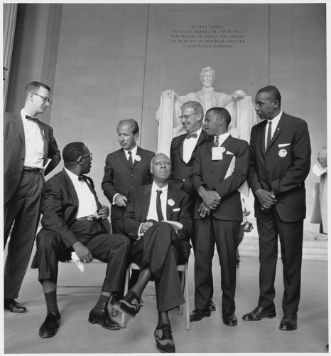 Though he organized one of the biggest rallies for human rights in US history, Bayard Rustin was not recognized publicly. The public leaders pictured here (L to R) are: Mathew Ahmann, Executive Director, National Catholic Conference for Interracial Justice; Cleveland Robinson, Chairman, Demonstration Committee; Rabbi Joachim Prinz, President, American Jewish Congress; A. Philip Randolph, founder, Brotherhood of Sleeping Car Porters; Joseph Rauh, Jr, a Washington, DC attorney and civil rights, peace, and union activist; John Lewis, Chairman, Student Nonviolent Coordinating Committee (SNCC); and Floyd McKissick, National Chairman, Congress of Racial Equality (CORE).