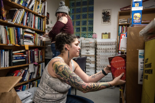 Volunteer Jennifer Beil looks through books while filling book requests from prisoners Wednesday, Jan. 25, 2023, in Madison, Wis. (Angela Major/WPR)