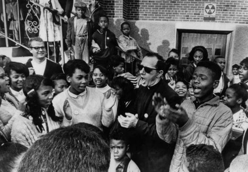 Father Groppi, a notable Milwaukee pastor and civil rights activist, with children during the 1965 MPS boycott. 